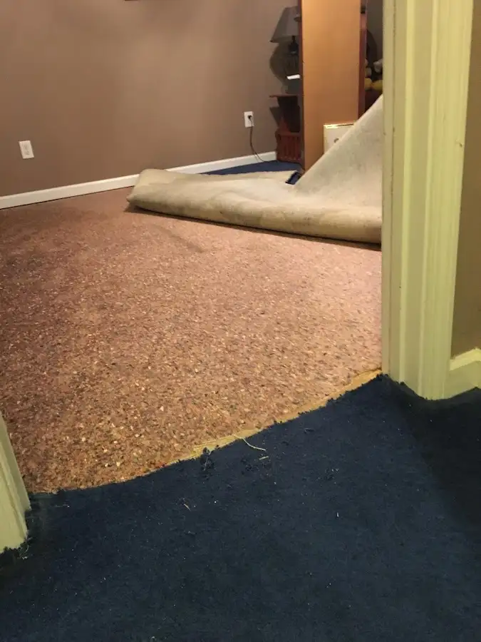 Carpet pad removal revealing water damage during Water Mitigation Services in Grand Terrace
